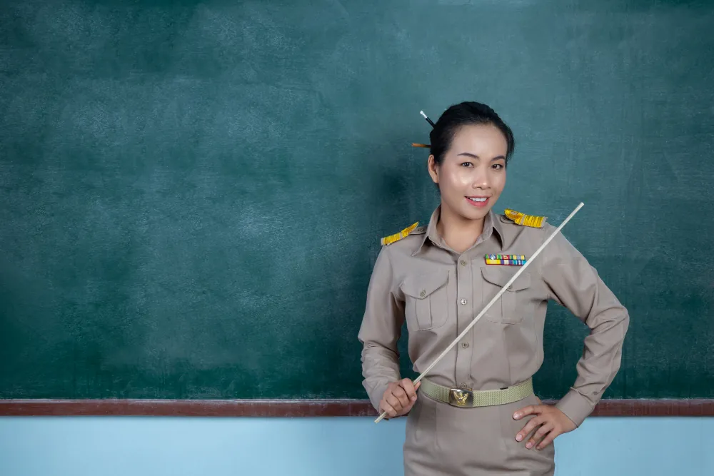 ครูไทยในชุดข้าราชการสีกากีหน้าห้องเรียน
